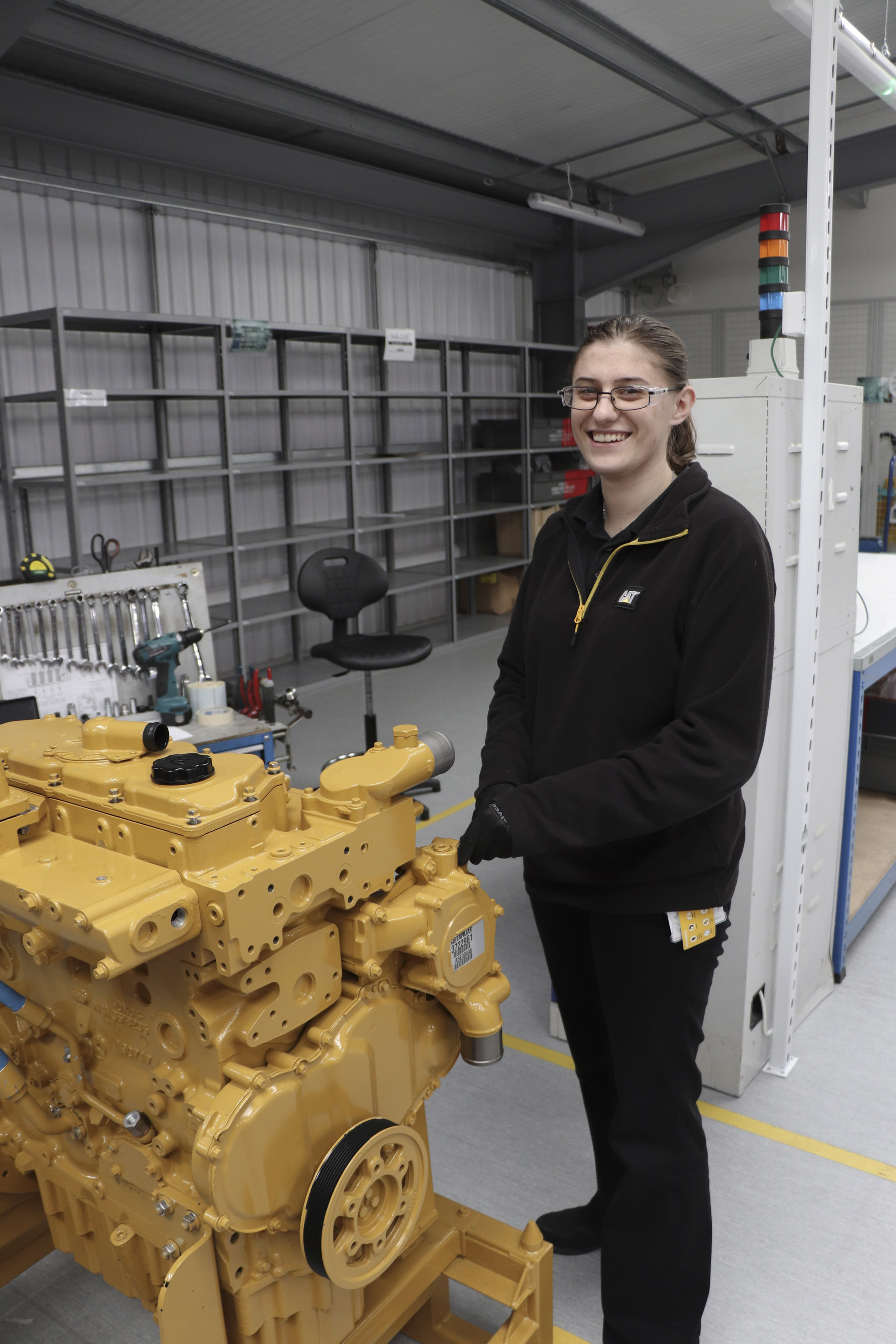 Apprentice standing with engineering machinery 